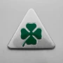 a metal triangle with a four leaf clover on it